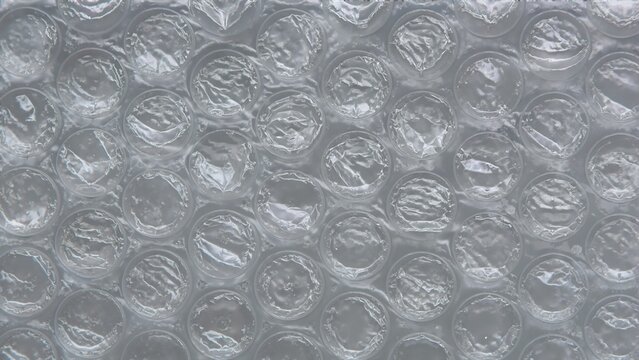 Clear plastic bubble wrap texture in close-up. Translucent protective packing sheet with air bubbles