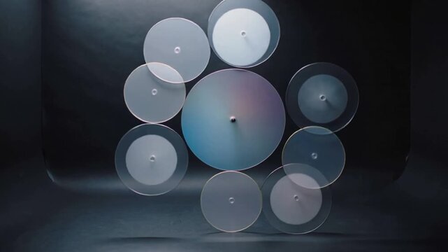 Motor starting, rotating sculpture with seven radial discs on spindle in gray studio