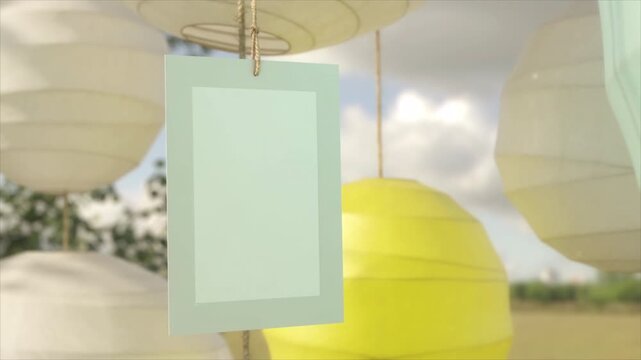 Blank vertical sign board hanging in a festive garden with bright yellow lanterns.