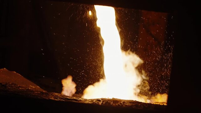 Molten Metal Pour with Sparks in Industrial Foundry Furnace