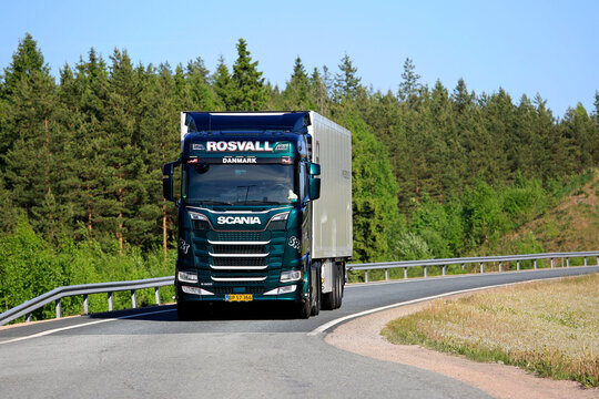 Next Generation Scania S500 semi-truck hauling FRC reefer trailer exits freeway on a sunny day of spring.