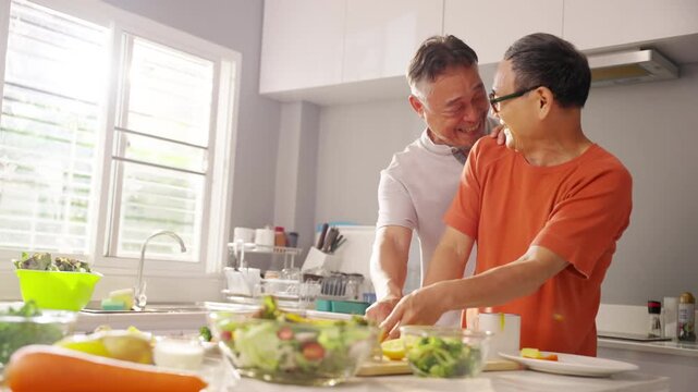 Happy Asian senior gay man couple preparing and enjoying healthy organic dinner together in kitchen at home, cooking fresh vegetables and sharing wellness routine for active retirement lifestyle.