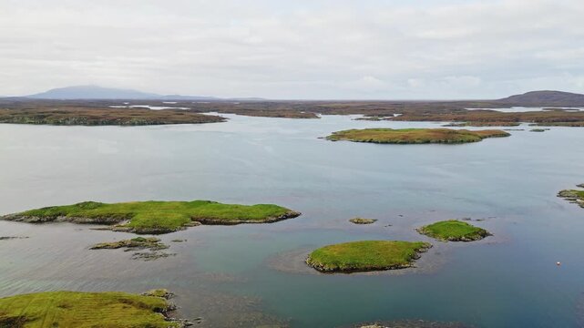 Grimsay near North Uist in the Outer Hebrides, Scotland, with coastal waters, secluded properties and rugged island landscape, Aerial cinematic reveal