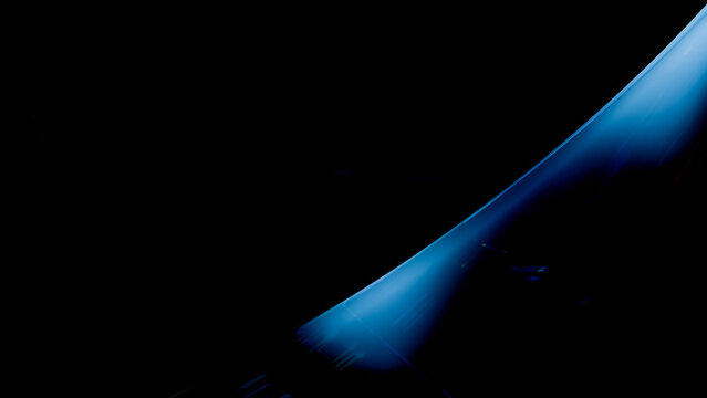 Stream of flowing blue water against black background