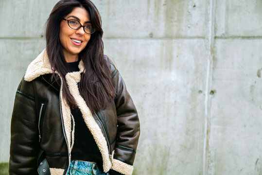 Beautiful young brunette woman with brown leather jacket and hat outdoor