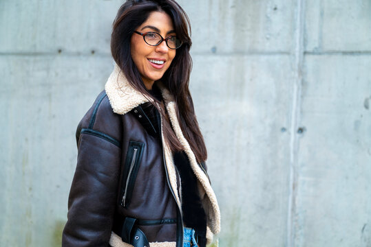 Beautiful young brunette woman with brown leather jacket and hat outdoor
