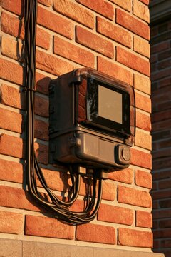 Modern electric meter on a brick wall in a residential area during the evening light