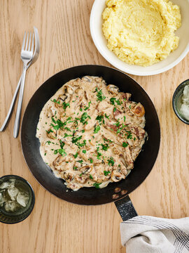 Creamy mushroom skillet with fresh herbs and mashed potatoes, home-cooked meal concept for family gatherings
