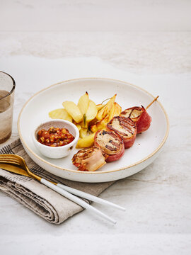 Chicken and bacon skewers with sweet potato wedges and dipping sauce, perfect for casual dining and family meals