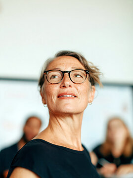 Portrait of Confident Mature Woman with Glasses Looking Up, business setting