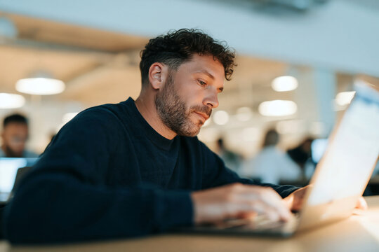 Confident Mature Man with Glasses and Beard Sitting in Bright Modern Office