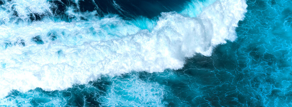 Banner Blue ocean Turquoise sea water white foam wave pattern splashing deep blue sea. Banner Tropical sea beach Seascape dark background splash on rock. Summer Ocean Surface wave with copy space