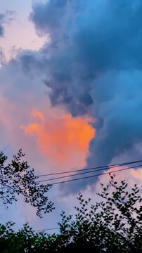 Vibrant sunset clouds glowing with orange light against a deep blue sky