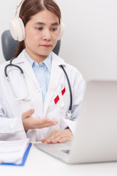 doctor using laptop for telehealth, online consultation and meeting about Burgundy and white ribbon to patient for concept of April Oral, Head and Neck Cancer Awareness month, Healthcare