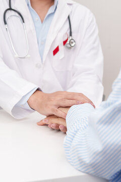 doctor hold patient hand to comfort and support with empathy. Burgundy and white ribbon to patient for concept of April Oral, Head and Neck Cancer Awareness month, Healthcare and February world cancer