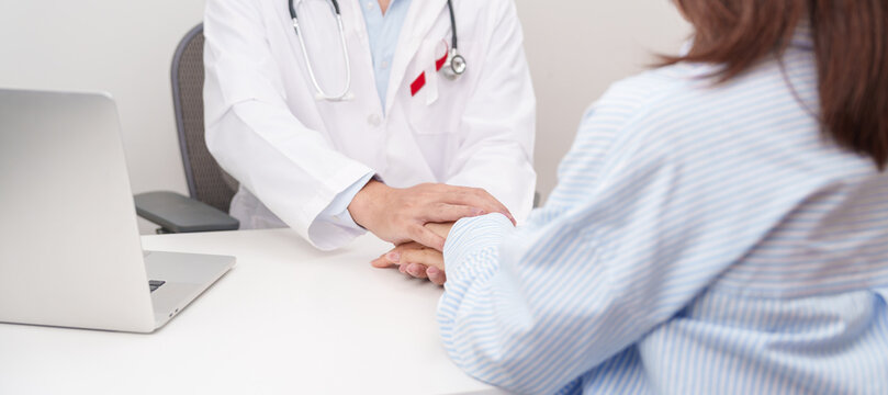 doctor hold patient hand to comfort and support with empathy. Burgundy and white ribbon to patient for concept of April Oral, Head and Neck Cancer Awareness month, Healthcare and February world cancer