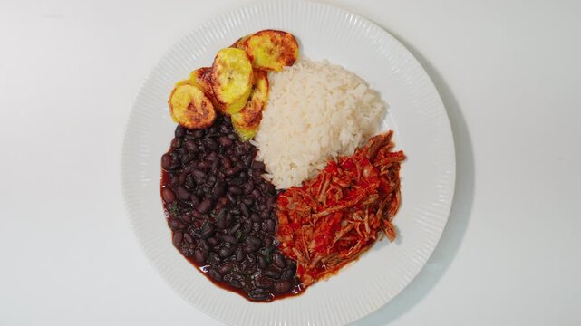 Traditional pabell&oacute;n criollo plating shredded beef, black beans, white rice, and fried plantains. Venezuelan cuisine.