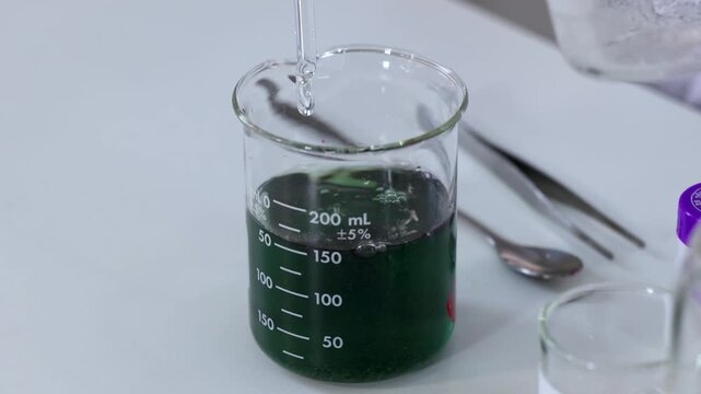 Chemical reaction showing color change in lab beaker with liquid solution.