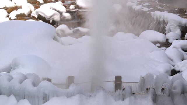 巨大なつららと勢いよく噴き出す渋の地獄谷噴泉の源泉と湯気のスローモーション