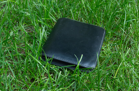 The lost wallet on the street, forgotten black leather object