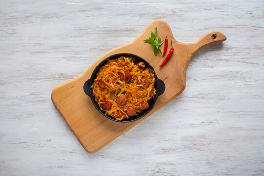 Traditional Polish bigos or braised cabbage with sausages in a rustic pan