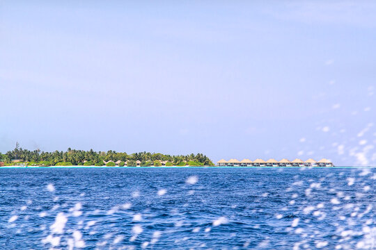 Maldives, View of a distant tropical island across the ocean.