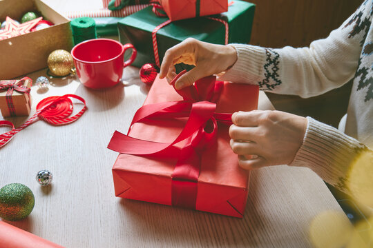 Woman wrapping Christmas gifts at home.
Preparing presents for loved ones reflects holiday shopping, seasonal celebrations, gift giving and the joy of Christmas traditions.