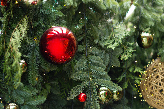 Christmas tree decorated with red and gold baubles and warm glowing lights, festive evergreen branches, elegant holiday background, cozy seasonal atmosphere, Christmas celebration, winter decor