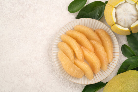 Fresh pomelo fruit with leaf on white table background.