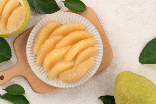 Fresh pomelo fruit with leaf on white table background.