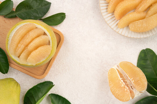 Fresh pomelo fruit with leaf on white table background.