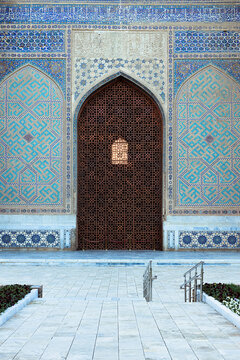 Bibi Khanym Mosque ornate entrance portal with intricate tilework and wooden lattice screen in Samarkand, Uzbekistan. Ideal for travel publications, cultural heritage features, and architectural.