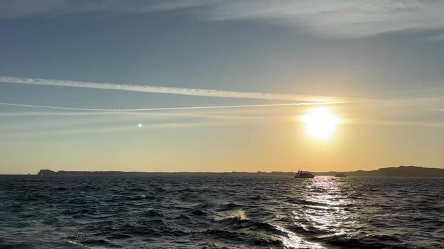 Golden sunset over ocean horizon in Ras Mohammed national park, Egypt panning view. Horizontal footage of sea waves and bright sun reflection from boat.