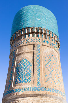 Chor Minor tower detail in Bukhara showing turquoise tilework and dome against clear blue sky. Ideal for travel publications and architectural reference materials.