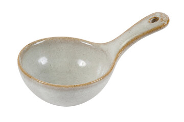 Single rustic ceramic measuring spoon with a speckled off-white glaze and brown rim is isolated on...