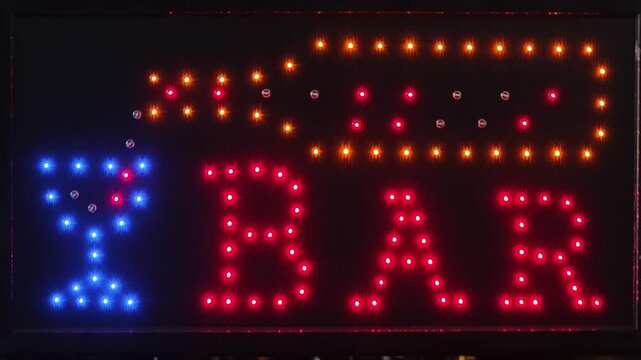 a BAR LED lighted sign featuring a glowing bottle pouring a drink into a blue cocktail glass next to the word BAR in red LEDs