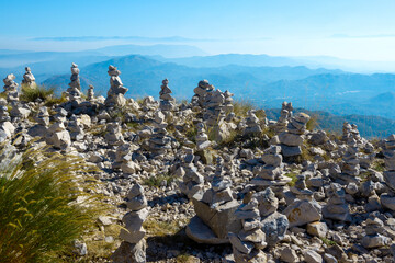 Stone turrets made by tourists for good luck among the green grass on top of Jezerski mountain near Njegos mausoleum. Lovcen National Park. Montenegro. © Yuriy Chertok