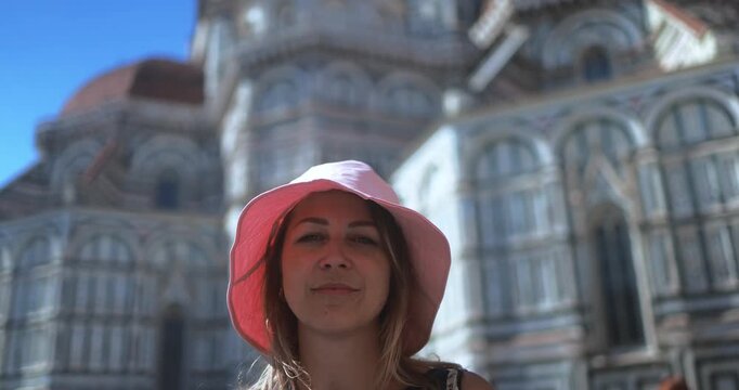 Young woman looking on camera with Florence city in background - Travel, vacation and tourism concept - UGC content