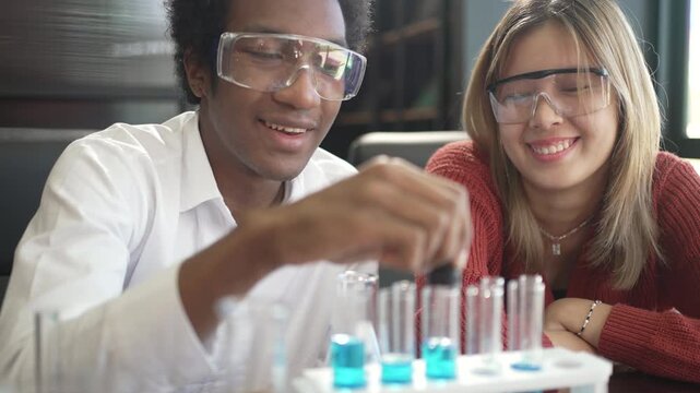 Teenage girl smiling as young man does chemistry experiment indoors
