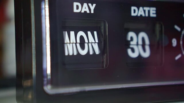 Classic clock face flipping day date numbers, dark ambiance, time change and daily schedule concept.