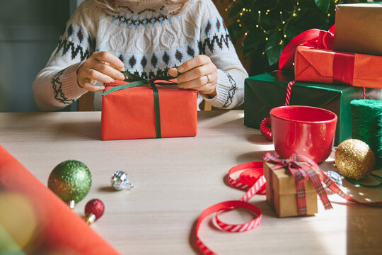 Woman wrapping Christmas gifts at home.
Preparing presents for loved ones reflects holiday shopping, seasonal celebrations, gift giving and the joy of Christmas traditions.