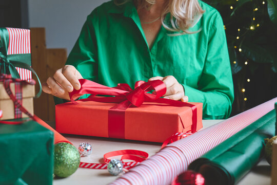 Woman wrapping Christmas gifts at home.
Preparing presents for loved ones reflects holiday shopping, seasonal celebrations, gift giving and the joy of Christmas traditions.