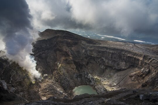 Steaming fumarole with crater lake on the Gorely volcano, Kamchatka, Russia