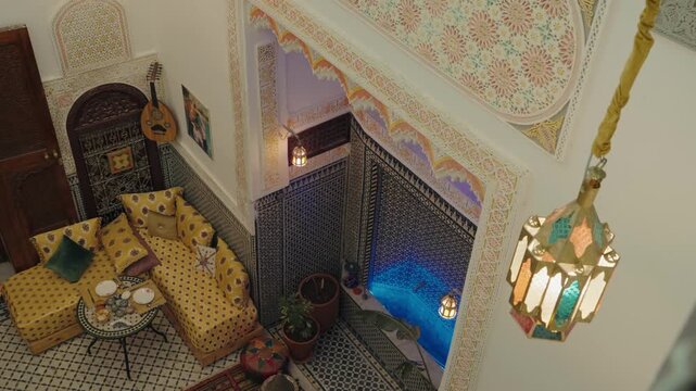 A cozy Moroccan courtyard with intricate tilework, vibrant yellow furniture, hanging lanterns, and a tranquil blue fountain. The scene evokes a sense of peace and exotic charm, Moroccan culture.