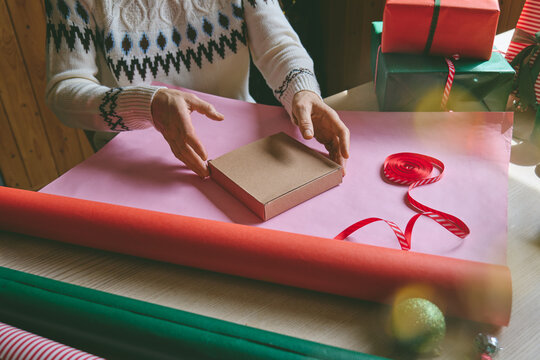 Woman wrapping Christmas gifts at home.
Preparing presents for loved ones reflects holiday shopping, seasonal celebrations, gift giving and the joy of Christmas traditions.
