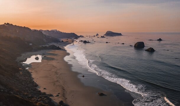 Sunrise, sandy beach, coastal landscape with many rugged rocky islands, Oregon, USA