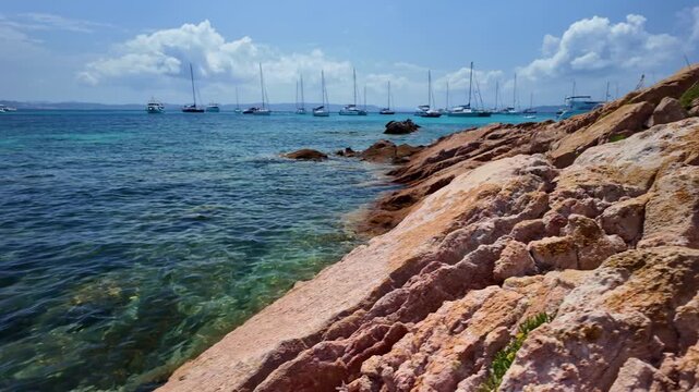 Panoramic view of the turquoise bay with yachts and boats off the coast of Santa Maria Island in the La Maddalena archipelago, Sardinia, Italy