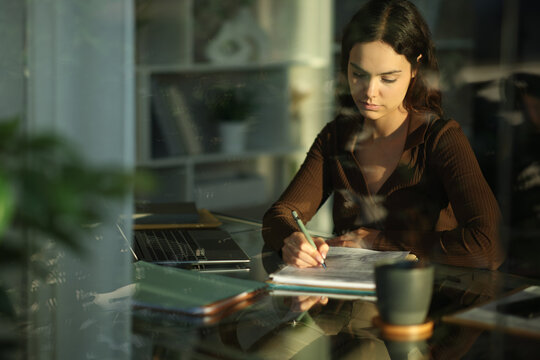 Serious young telecommuter filling out form working at home