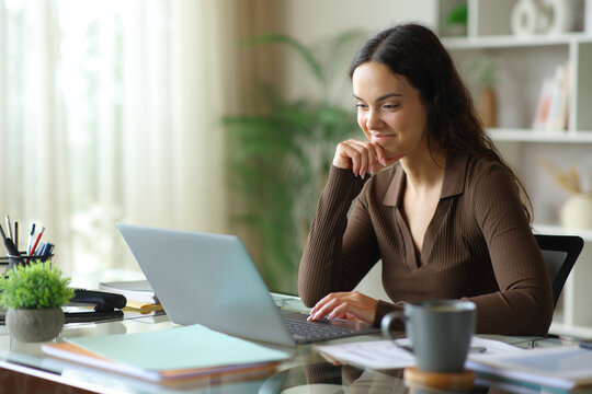 Satisfied telecommuter checking laptop working online at home