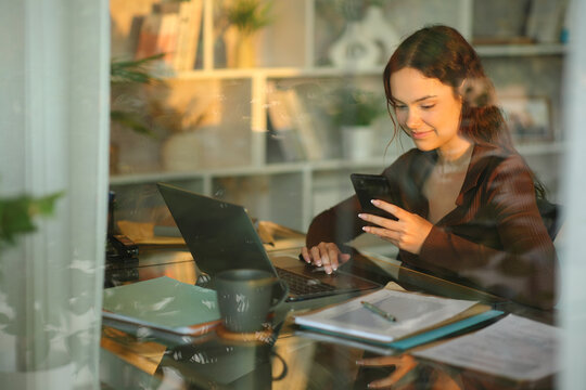 Telecommuter working online at home checking phone